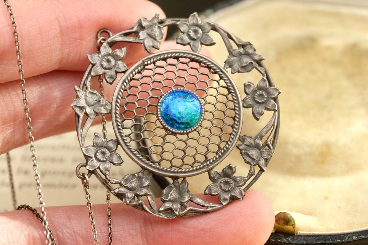 Art Nouveau sterling silver floral pendant necklace held in hand