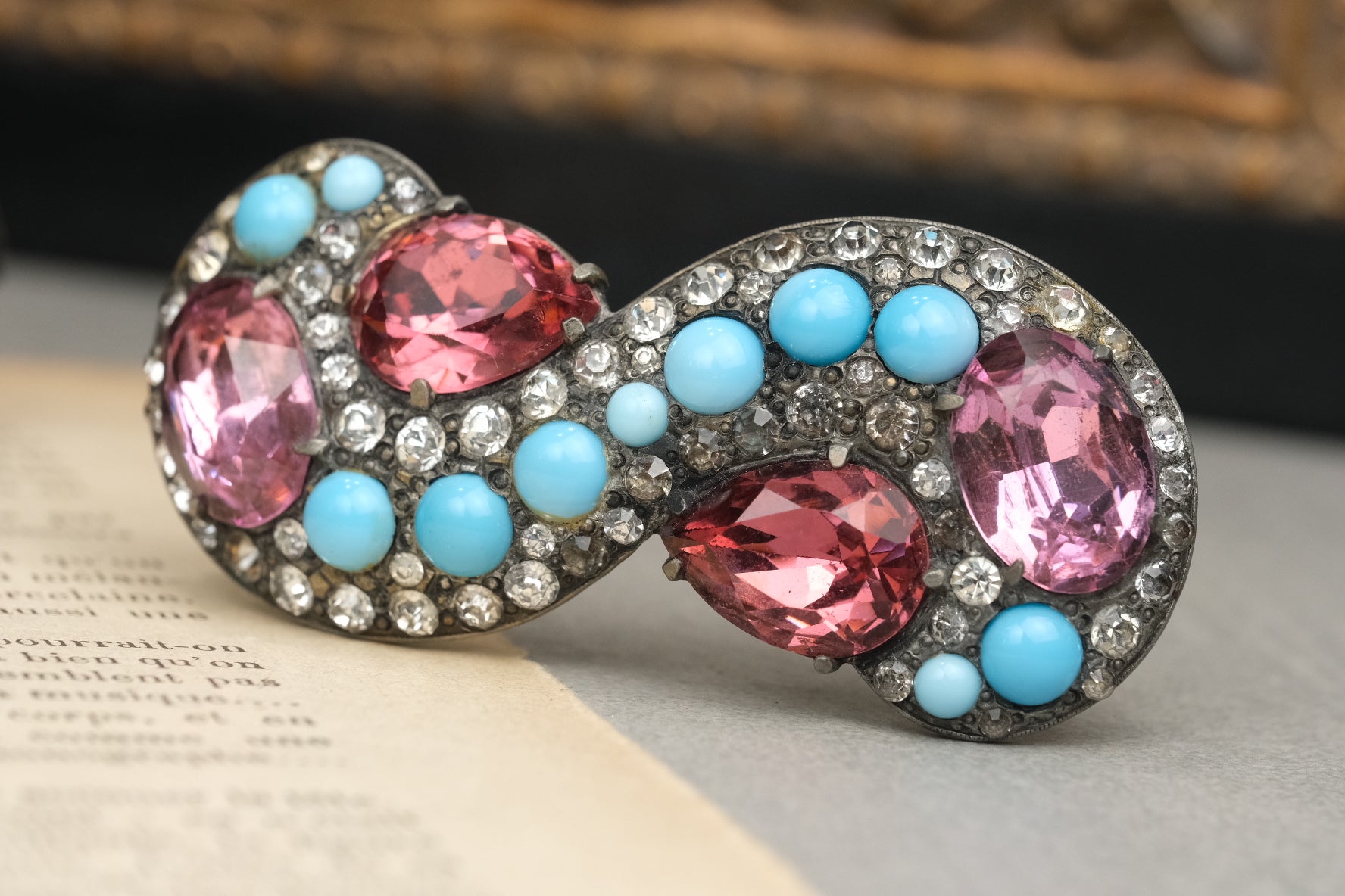 Angled view of pink glass stones, blue cabochons, and rhinestones on Eisenberg Original brooch