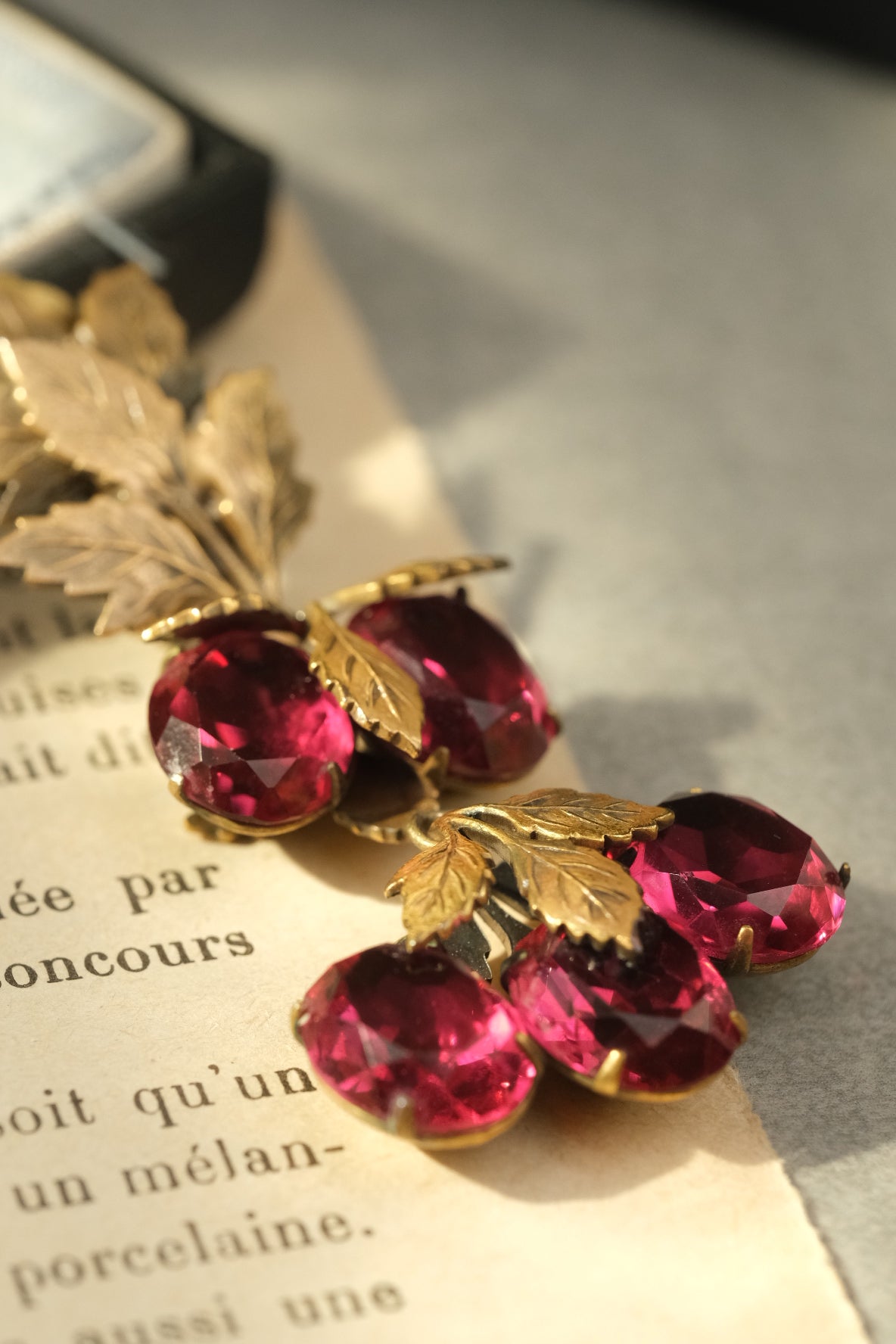 Close-up of transparent ruby glass stones and dimensional gold-tone leaves
