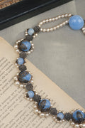 Blue glass bead necklace with lace-like metal flower plaques detail