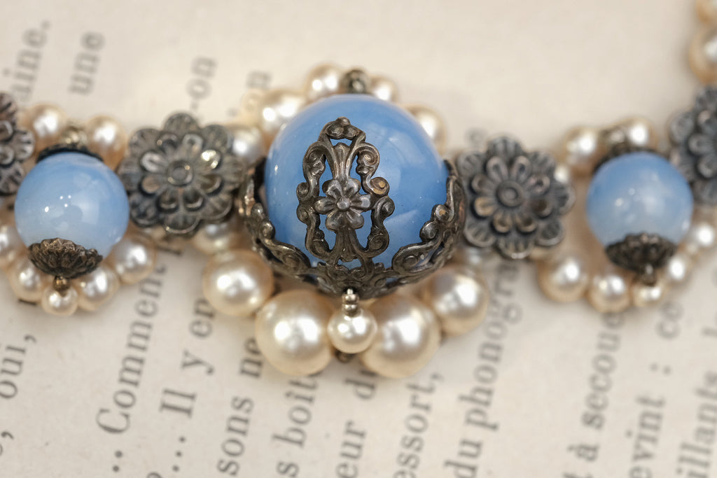 Ornate blue glass bead with lace-like metal floral setting