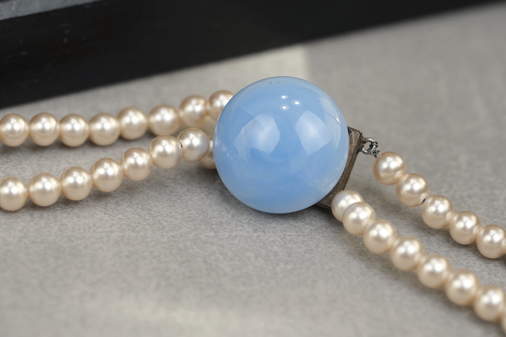 Blue glass clasp and double strand pearl necklace detail