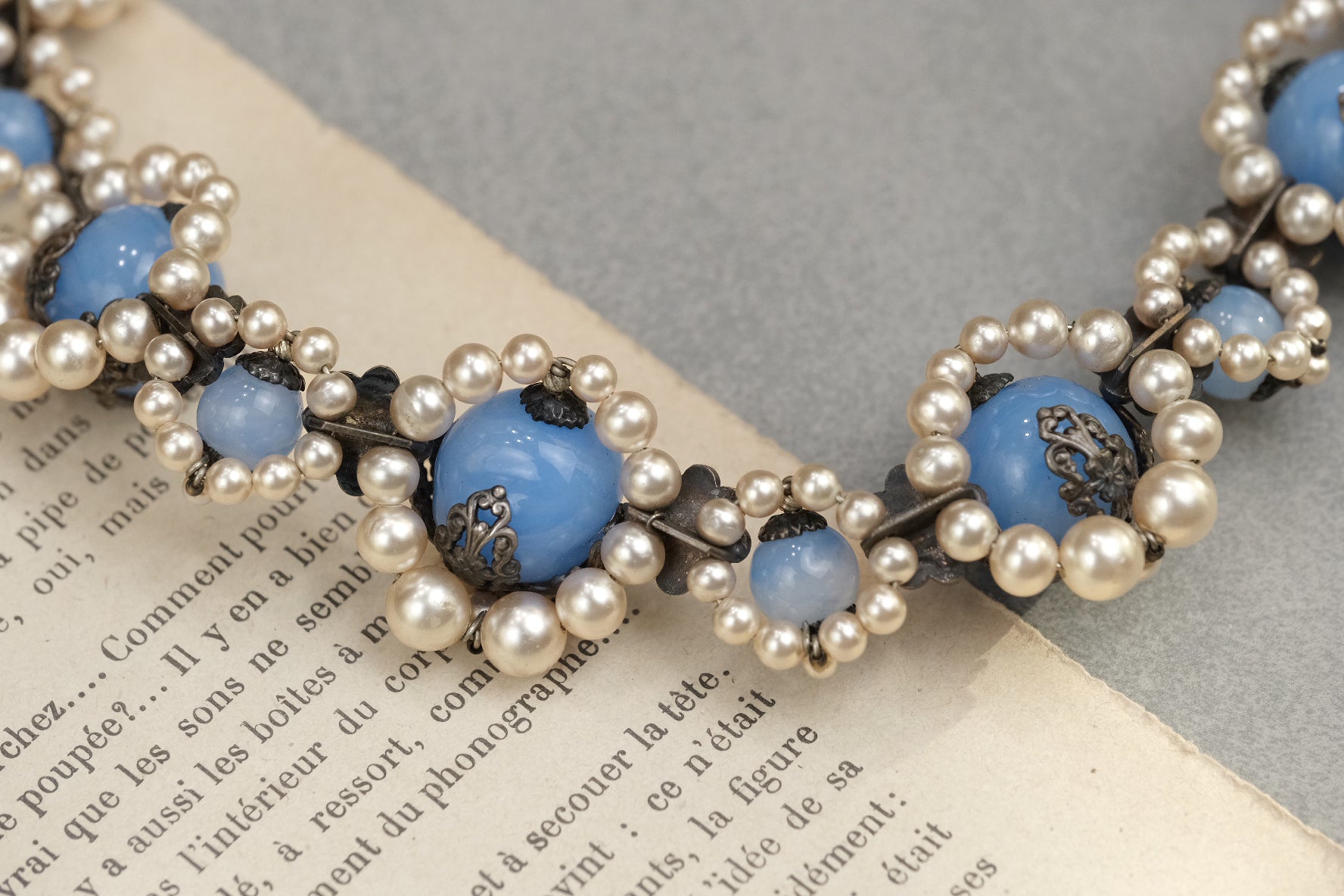 Reverse construction of blue glass and pearl floral necklace