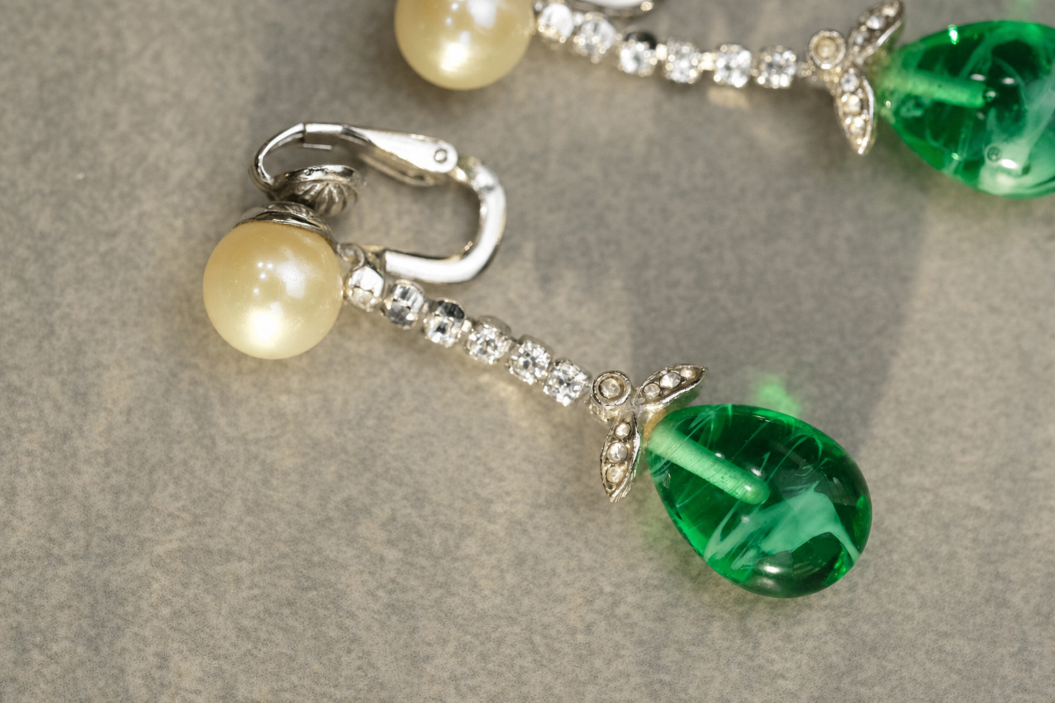 Ciner signed clip-on earring with faux pearl, rhinestone strand, and green glass drop