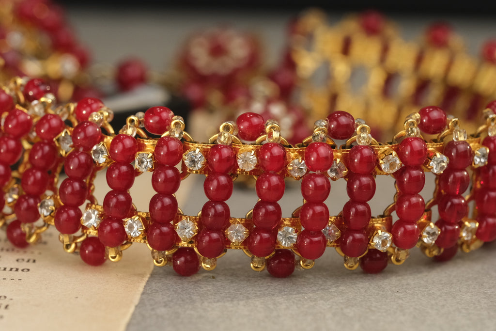 Detailed view of translucent red glass beads and rhinestone-set necklace