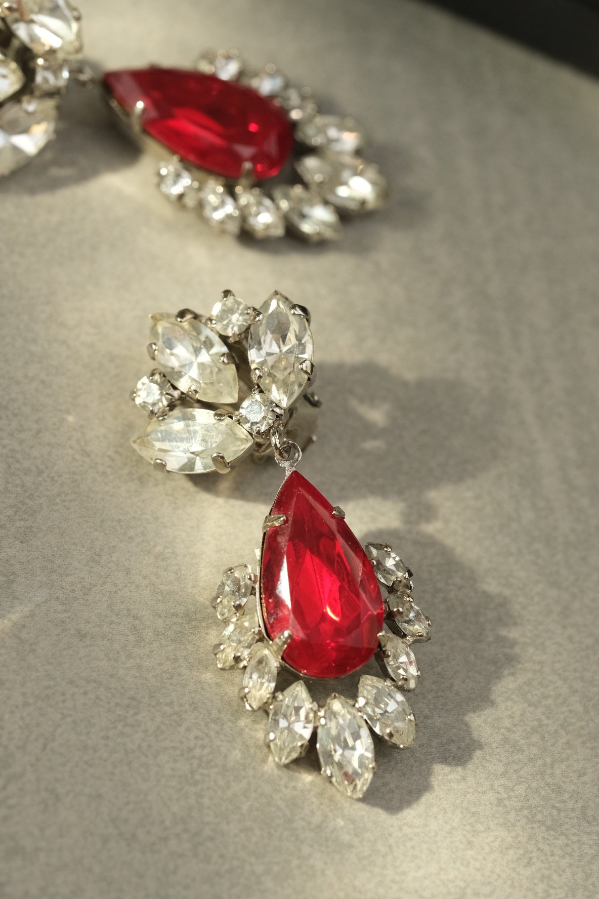 Close-up of ruby red teardrop glass stone and marquise rhinestones