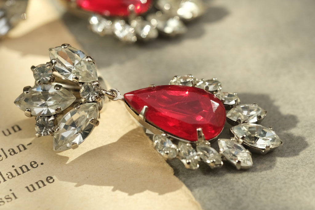 Side detail of faceted red glass and clear rhinestone vintage earrings