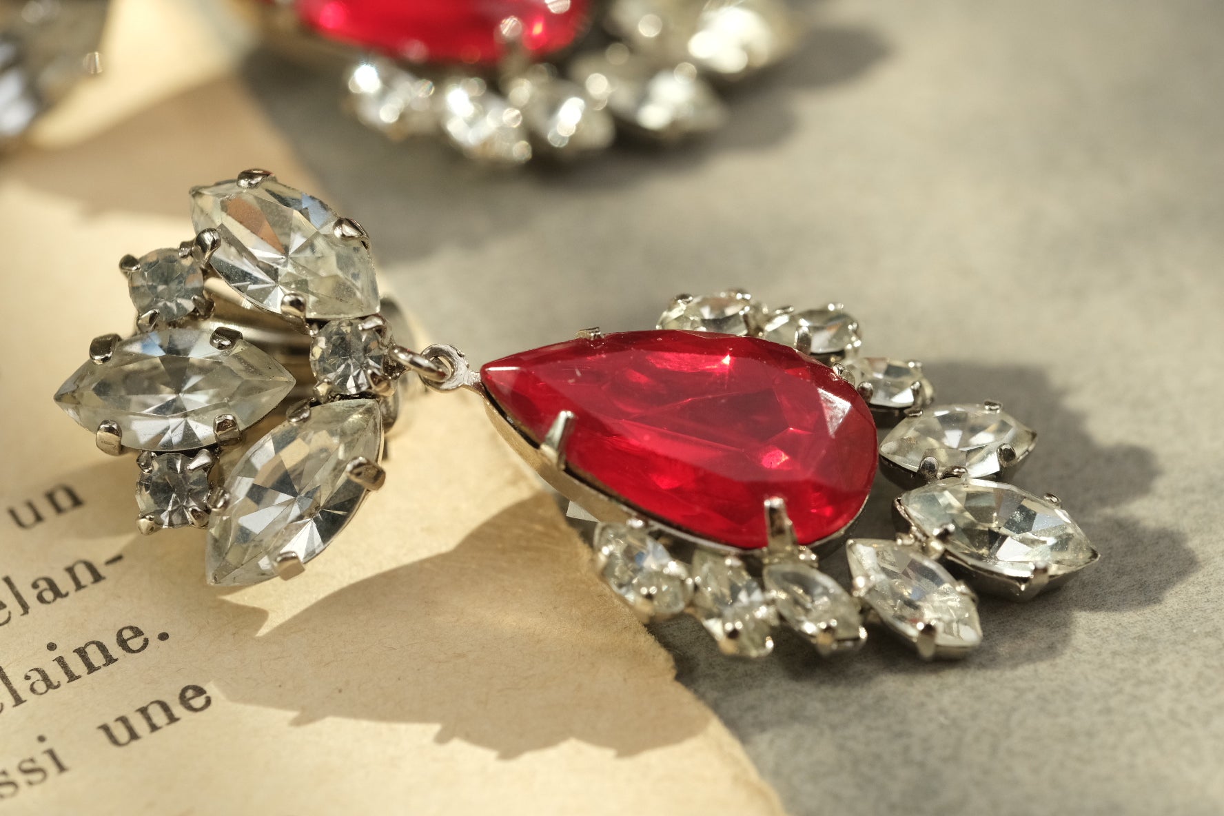 Side detail of faceted red glass and clear rhinestone vintage earrings