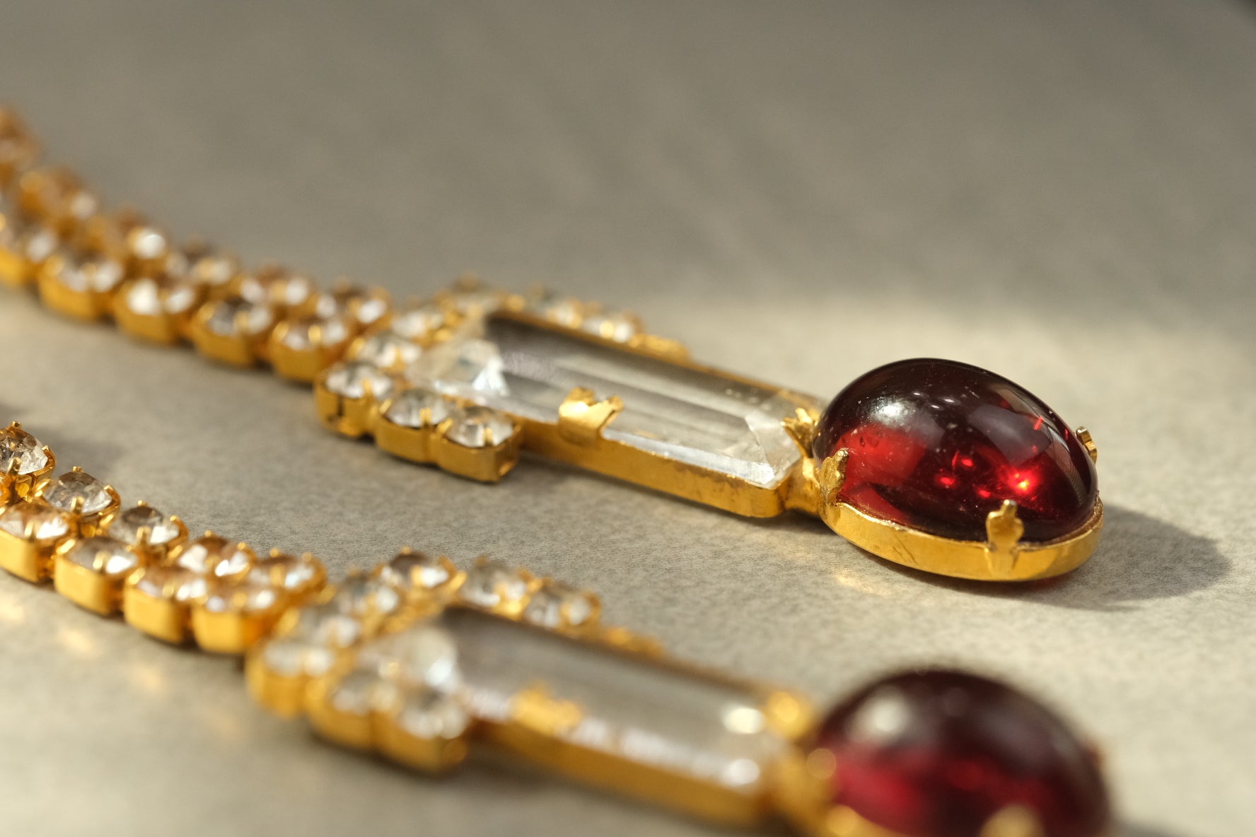 Side profile of ruby glass cabochon and clear glass drop earrings
